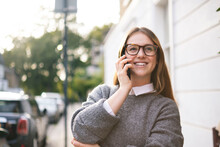 Happy Young Woman Wearing Eyeglasses Talking On Mobile Phone