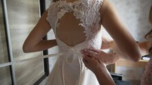Woman Help Lace Up White Bride Romantic Dress Corset While Bridesmaid Helps