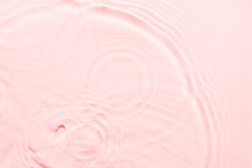 Wall Mural - Water pink surface abstract background. Waves and ripples texture of cosmetic aqua moisturizer with bubbles.