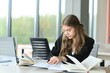 © Serhii - A cute schoolgirl is sitting at a desk at school. The concept of schooling.