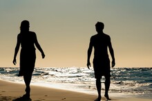 AI Generated Illustration Of Two Figures Silhouetted Against A Sunset On A Beach