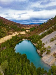 Poster - Aerial view of the picturesque Lochan Uaine, surrounded by lush trees in the Scottish Highlands