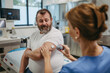 Doctor applying a continuous glucose monitor sensor on patient's arm. Obese, overweight man is at risk of developing type 2 diabetes. Concept of health risks of overwight and obesity.