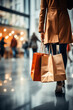 © VicPhoto - Personas de compras en un centro comercial con bolsas.