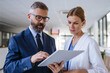 © Halfpoint - Pharmaceutical sales representative talking with female doctor in medical building. Hospital director consulting with healthcare staff.