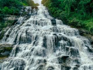 Wall Mural - beautiful waterfall in lush tropical green forest. nature landscape. mae ya waterfall is situated in