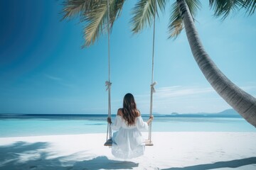 Wall Mural - A graceful lady in long skirt on a swing by a beautiful sandy beach. Summer tropical vacation concept.
