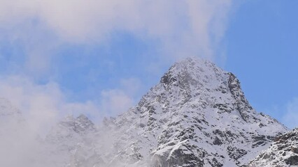 Wall Mural - Snowy peak with moving clouds