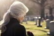 In Silent Remembrance: A Mature Lady Bows Her Head in Mourning Beside a Grave, Grieving the Loss with Profound Sorrow, Contemplation, and a Heart Heavy with Memories