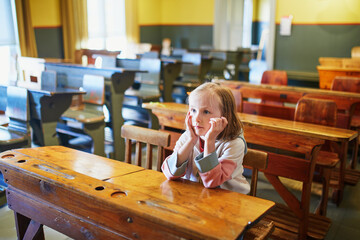 Wall Mural - Attentive preschooler girl in class at desk