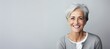 © Martin - Serenade of Joy: On a Plain Grey Background, a Mature Lady's Smile Captures the Essence of Contentment, Cheerfulness, and the Beauty of Aging Gracefully