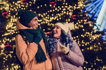 Wall Mural - Portrait of optimistic carefree funny laughing nice friends guy girl having fun look at each other fir tree ferris wheel on background