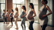 A group of pregnant women in sportswear doing yoga in the gym.