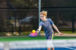 Boy playing pickleball on court