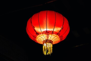 Bright red Chinese lantern against a black background.