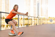 Athletic woman doing workout on city bridge