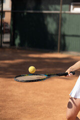 Tennis play young girl kicks ball on racquet. Close up shot tennis ball on racket. Sports woman juggles. Advertisement of tennis ball and racket. Warmup before training