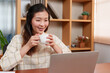 © Ekkasit A Siam - Asian woman working on laptop, placed on desk in office room, because was sleepy, brought coffee drink while working relieve sleepiness, when drank coffee became more alert.