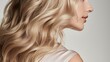 © Cloudyew - Close up of long, wavy blonde hair on a plain backdrop