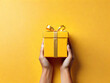 Yellow giftbox in hands