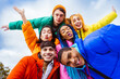 Multiracial group of young friends meeting outdoors in winter - Multiethnic students with colorful winter jackets and stylish outfits having fun in the city