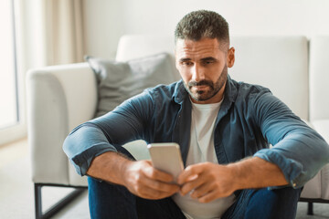 Poster - Middle aged guy texting on smartphone while having issues indoor