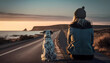 a woman sitting next to a dog on a road near the ocean at sunset with a dog looking out the window