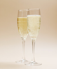 Two champagne glasses on a beige