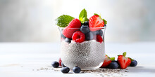 Delicious chia pudding with fresh berries in a glass jar on table with blurred background, healthy dessert concept 