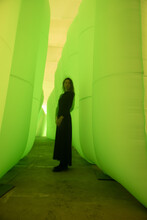 Long Exposure Art Portrait Of Woman In Black Dress In Green Light Tunnel