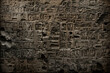 Cuneiform or Egyptian hieroglyphs of Ancient civilization carved on dark stone wall. Undeciphered signs like Sumerian and Babylonian writing. Concept of mystery, old script, puzzle