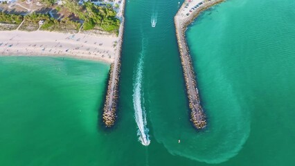 Canvas Print - Rock jetty barrier and boats sailing at harbor on colorful ocean water near Venice and Nokomis beach in Sarasota County, USA