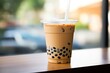 Boba or tapioca pearls, known as Taiwanese bubble milk tea, are served in a plastic cup with a delightful brown sugar flavor.