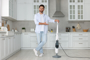 Wall Mural - Happy man with steam mop in kitchen at home