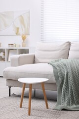 Poster - Knitted plaid on comfortable sofa in living room