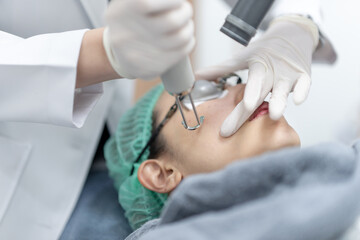 Wall Mural - Woman receiving pico laser facial treatment in beauty Clinic.