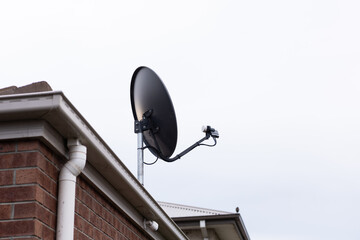 satellite tv dish antenna on house roof