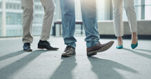 Business People, Legs And Team Standing At Office In Meeting, Interview Or Waiting Room. Closeup Of Corporate Employees, Formal Shoes Or Feet In Teamwork For Hiring, Recruiting Or Growth At Workplace