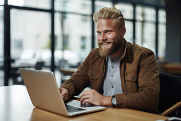 Canvas Print - Man sitting in front of laptop computer. Suitable for technology, remote work, or online learning concepts.