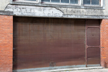 Wall Mural - Old closed rusty metal rolling shutters on facade entrance old building