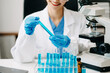 © Nuttapong punna - Female scientist researcher conducting an experiment working in chemical laboratory.