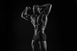 © andy_gin - Silhouette of a strong bodybuilder. Confident young fitness athlete with a powerful body and perfect abs. Black and white photography. Dramatic light.