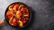 Christmas baked chicken with cranberries and oranges in a frying pan on a gray background top view copy space for text