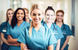 © Victor - Smiling group of women healthcare professionals wearing scrubs and posing together in a hospital. Portrait of diverse female nurses together.