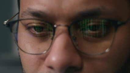 Man in eyeglasses reflection of green numbers in glasses male programmer in front of display looking laptop coding data finance bitcoin crypto business code businessman reflect of computer screen