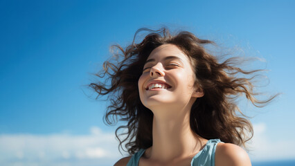 Wall Mural - A Brunette woman breathes calmly looking up isolated on clear blue sky