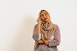 © iBennn - Asian Muslim woman wearing hijab or headscarf thinking while look up. Indonesian woman on white background.