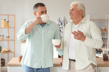 Canvas Print - Mature brothers drinking tea in kitchen