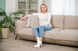 © brizmaker - woman sitting on sofa and relaxing in cozy living room