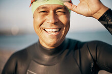 Smiling Man In A Wetsuit Putting On Goggles Before An Open Water Swim